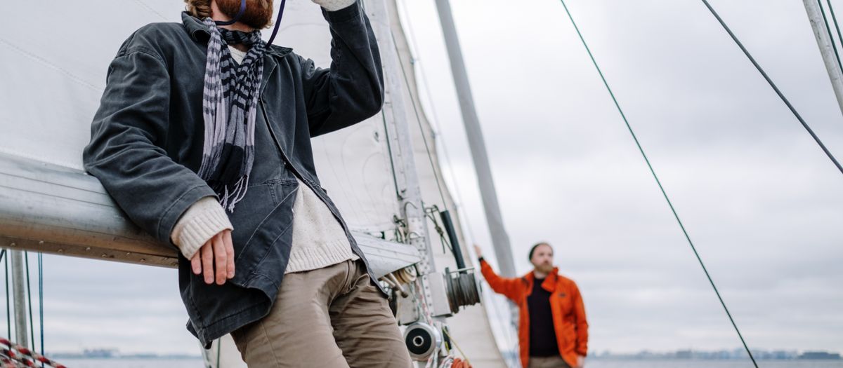A pair of binoculars on a boat rail with open water and a hazy horizon behind.